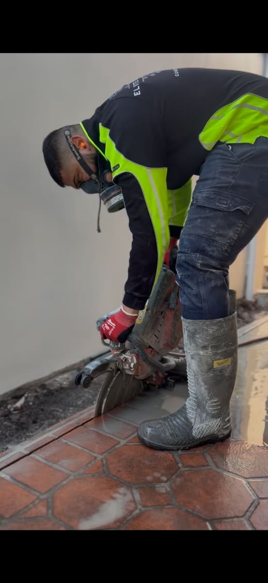 Floor sawing through a tiled concrete floor inside a house