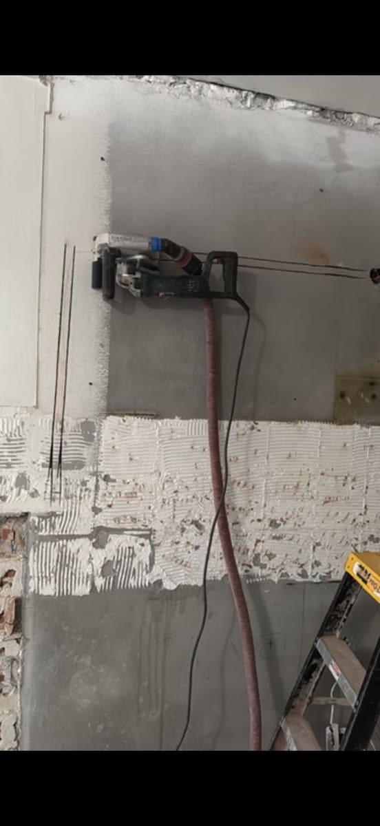 Opening cut into a wall, saw resting on the floor