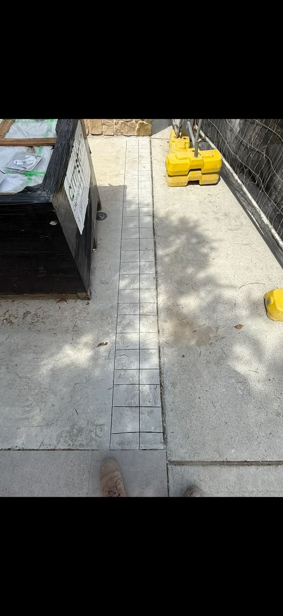 Saw cutting through pavers and the slab beneath