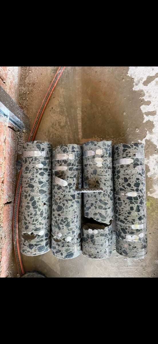 Concrete cores drilled and removed from a slab, stood up on site