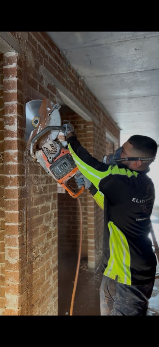Cutting through a double brick wall with a hand saw on a site in Sydney’s Eastern Suburbs