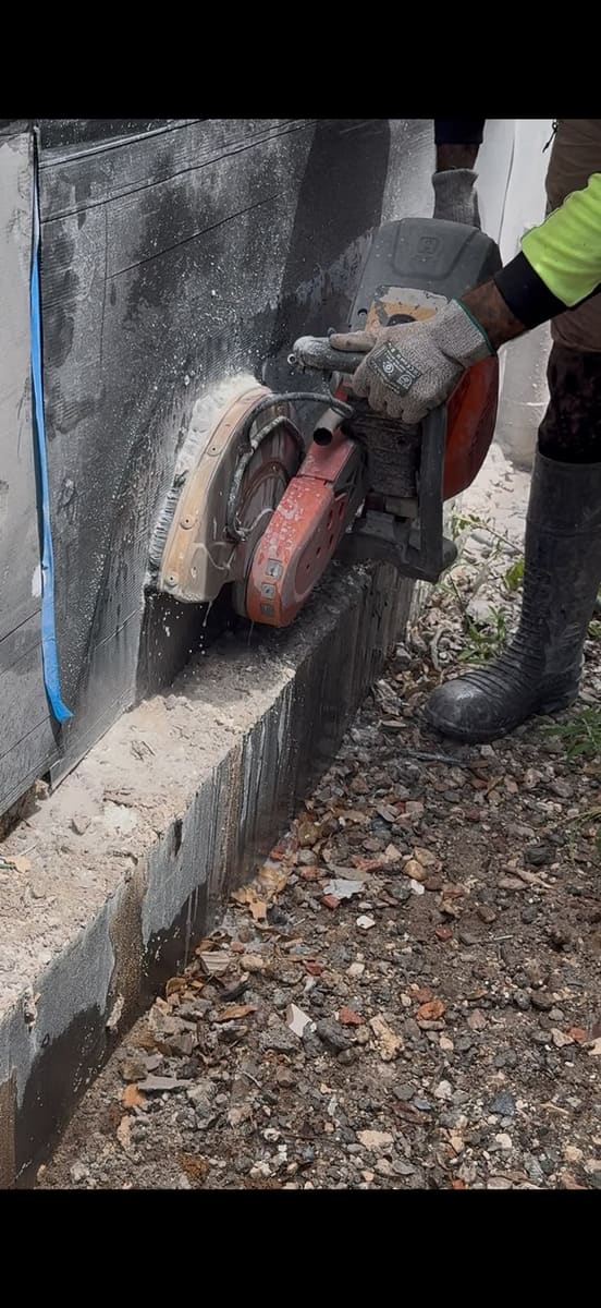 Hand sawing a concrete kerb and edge outdoors